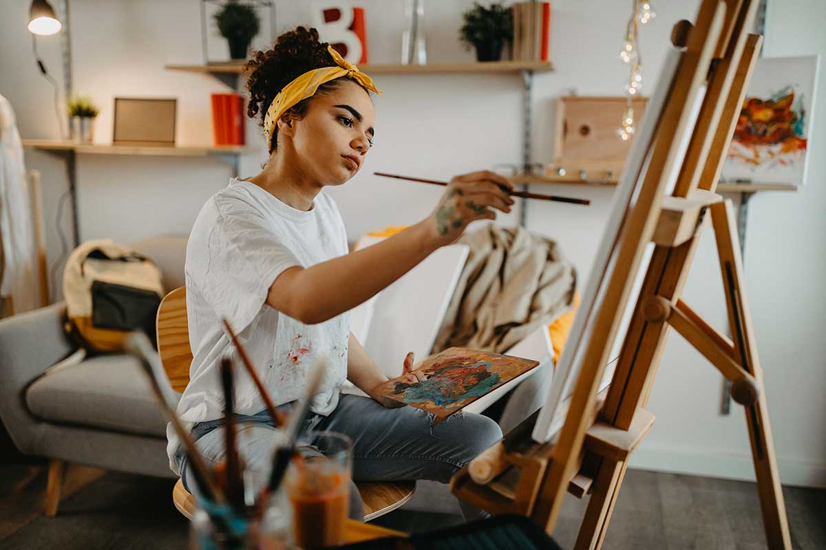 Girl in art studio painting on canvas